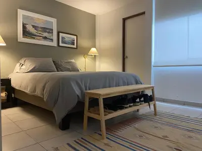 a bedroom with a bed with a table next to it at Watermanhouse, Punta Hermosa in Lima