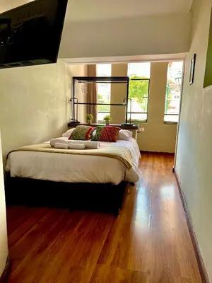 a bedroom with a large bed with wooden floors at Hostal María Angola in Cusco