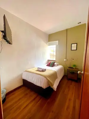 a bedroom with a bed and a television in it at Hostal María Angola in Cusco