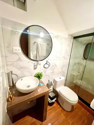 a bathroom with a sink and a toilet and a mirror at Hostal María Angola in Cusco