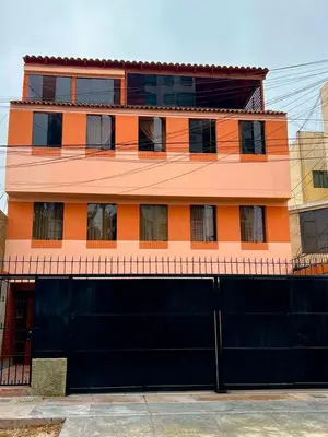 a building with an orange and black garage at San Miguel, 3 dormitorios, terraza wifi cochera in Lima