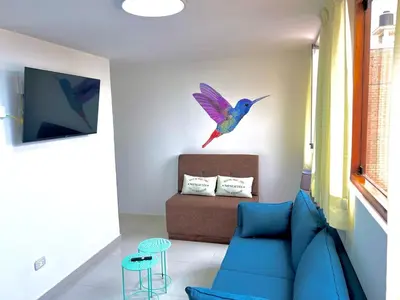 a living room with a blue couch and a bird on the wall at San Miguel, 3 dormitorios, terraza wifi cochera in Lima