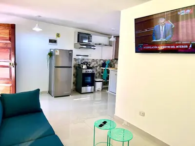 a living room with a couch and a tv on a wall at San Miguel, 3 dormitorios, terraza wifi cochera in Lima