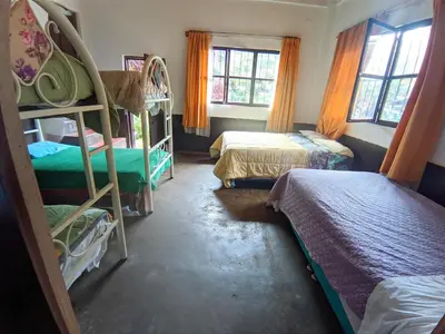 a room with three bunk beds and two beds at la casa de mamá in Huayopata