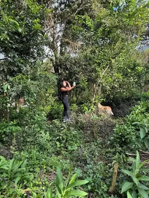 a woman taking a picture in the forest at la casa de mamá in Huayopata