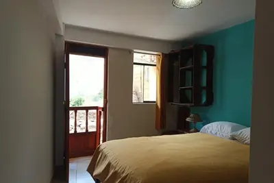 a bedroom with a bed and a window at Casa D´Maria in Ollantaytambo