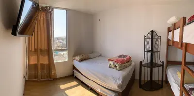 a bedroom with two bunk beds and a window at Apartment 03 dormitorios San Miguel in Lima