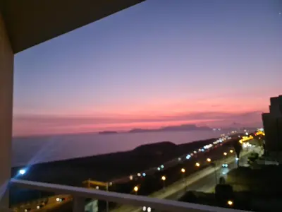 a view of a sunset from a balcony of a city at Apartment 03 dormitorios San Miguel in Lima