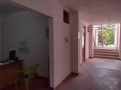 a hallway with a chair and a table and a door at 420 Route's Backpackers in Nazca