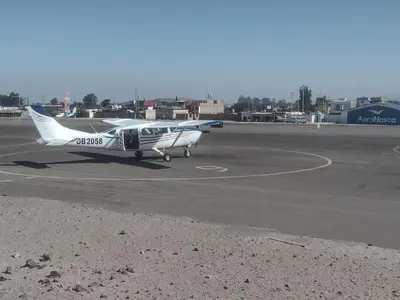 a small plane sitting on the runway at an airport at 420 Route's Backpackers in Nazca