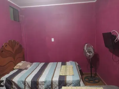 a small bedroom with a bed and a fan at 420 Route's Backpackers in Nazca