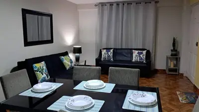a living room with a table and a couch at Lopez House in Lima