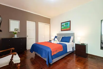 a bedroom with a bed with blue and orange sheets at Charming Miraflores Guesthouse with Terrace Studio Apartment and Private Room in Lima