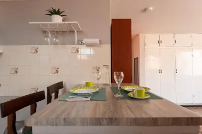 a kitchen with a wooden table with plates and wine glasses at Charming Miraflores Guesthouse with Terrace Studio Apartment and Private Room in Lima