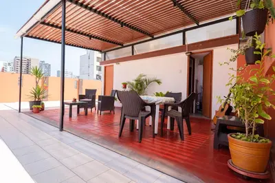 a patio with a table and chairs on a roof at Charming Miraflores Guesthouse with Terrace Studio Apartment and Private Room in Lima