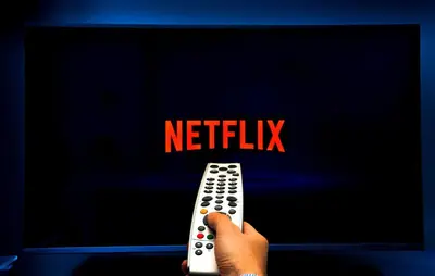 a person holding a remote control in front of a tv at Hostal Venus - Nueva Imagen in Huacho