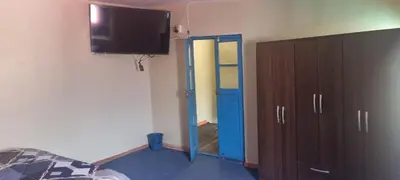 a bedroom with a blue door and a tv on the wall at CASA HOSPEDAJE LA FLORIDA in Cusco