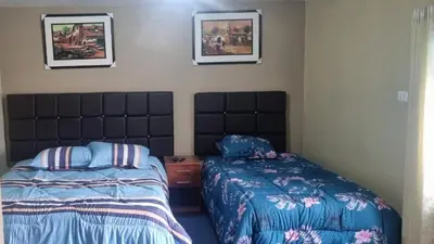 a bedroom with two beds and two pictures on the wall at CASA HOSPEDAJE LA FLORIDA in Cusco