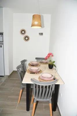 a dining room table with chairs and plates on it at Departamento Moderno - Zona Exclusiva - Huacachina in Ica