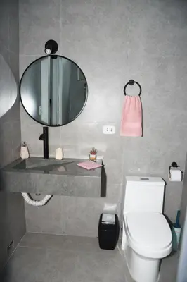 a bathroom with a white toilet and a mirror at Departamento Moderno - Zona Exclusiva - Huacachina in Ica