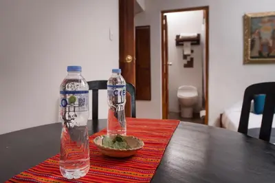 two bottles of water and a bowl of food on a table at CASA HOSPEDAJE EL LABRADOR in Cusco