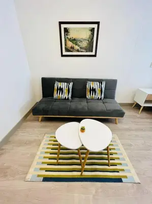 a living room with a black couch and two white tables at Apartment with incredible view, pool and gym in Lima