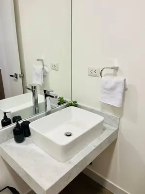 a bathroom with a white sink and a mirror at Apartment with incredible view, pool and gym in Lima