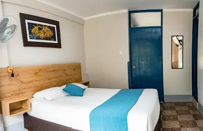 a bedroom with a bed and a blue door at Casa Plaza Bolivar in Quillabamba