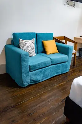 a blue couch with two pillows on it in a living room at Casa Plaza Bolivar in Quillabamba