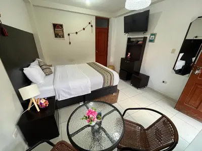 a hotel room with a bed and a table and chairs at Hotel Perumanta Boutique in Cusco