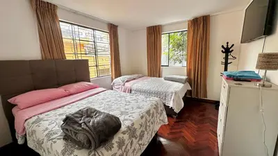 a hotel room with two beds and a television at Casa Verde Jesús María - Zona Residencial in Lima