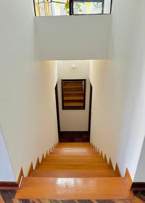 a staircase in a house with white walls and wooden floors at Casa Verde Jesús María - Zona Residencial in Lima