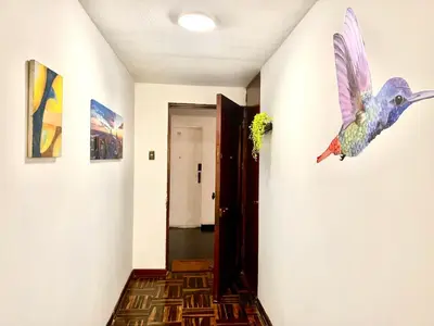 a hallway with a painting of a bird on the wall at Pershing, depa bonito, 3camas wifi/cable in Lima