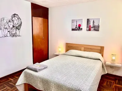 a bedroom with a bed and two pictures on the wall at Pershing, depa bonito, 3camas wifi/cable in Lima