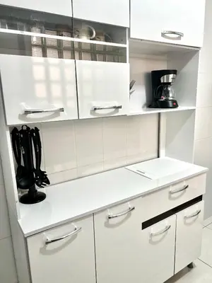 a white kitchen with white cabinets and black shoes at Pershing, depa bonito, 3camas wifi/cable in Lima