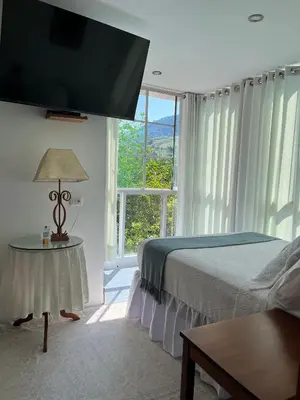 a bedroom with a bed and a large window at Albergue Turístico Gstir in Pozuzo