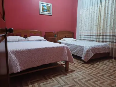 two beds in a room with red walls at MI SELVA Y SU ENCANTO in La Merced