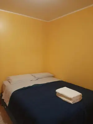 a bedroom with a bed with two towels on it at Casa La Ruta Pisco in Pisco