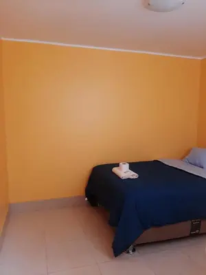 a bedroom with a bed and a yellow wall at Casa La Ruta Pisco in Pisco