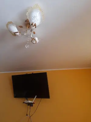 a ceiling with a chandelier and a tv in a room at Casa La Ruta Pisco in Pisco