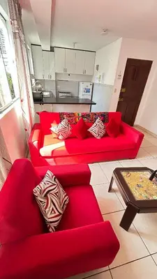 a living room with two red couches and a table at Hermoso Apartamento Miraflores Central in Lima