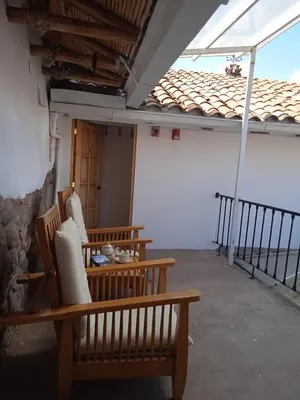 a room with two chairs and a table and a balcony at SAMANA B&B in Cusco