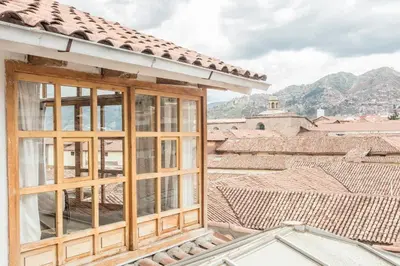 a window on a house with mountains in the background at SAMANA B&B in Cusco