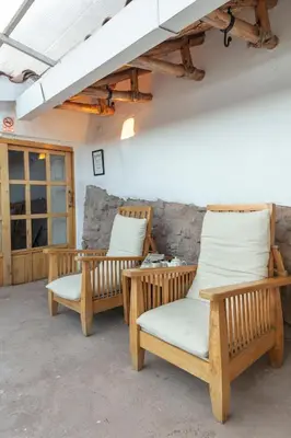 two wooden chairs sitting next to a wall at SAMANA B&B in Cusco