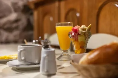 a table with two glasses of orange juice and bread at SAMANA B&B in Cusco