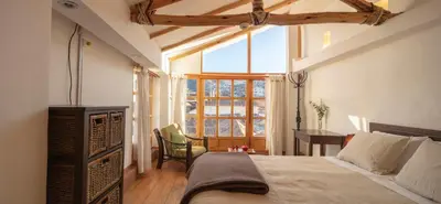 a bedroom with a bed and a desk and a window at SAMANA B&B in Cusco
