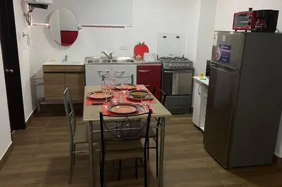 a kitchen with a table with chairs and a refrigerator at (29) Dpto Nuevo y Acogedor Miraflores in Lima