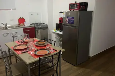 a small kitchen with a table and a refrigerator at (29) Dpto Nuevo y Acogedor Miraflores in Lima