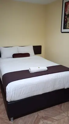 a bedroom with a large bed with white sheets at La Casita de Gabriel in Cusco