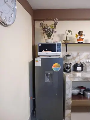 a small refrigerator with a microwave on top of it at La Casita de Gabriel in Cusco
